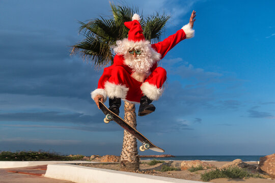 Mature man wearing Santa Claus costume skateboarding on footpath