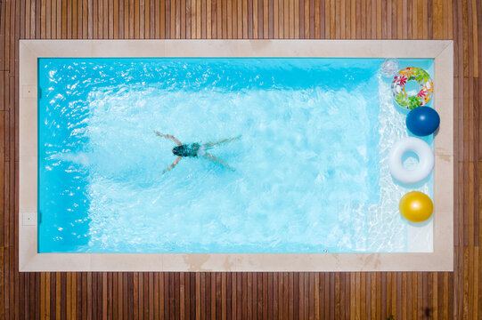 Girl swimming in pool on sunny day