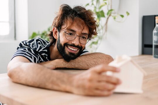 Happy Man With Small House Model At Home