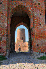 Fototapeta na wymiar Gothic castle of the Dukes of Mazovia build in 14th and 15th century by Prince Janusz I Elder. Tower with entrance gate. The castle is located in Czersk, Masovian voivodeship, Poland.