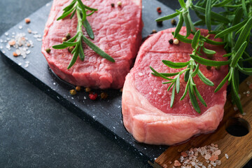 Steaks. Fresh Filet mignon Steaks with spices rosemary and pepper on black marble board on gray background. Top view. Mock up.