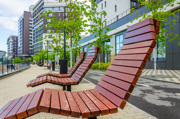 Wooden chairs for relaxing are on the river embankment.