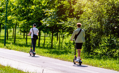 boys rides an electric scooter in the summer Park
