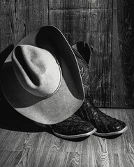 Vertical closeup of boots and an old-fashioned hat shot in grayscale