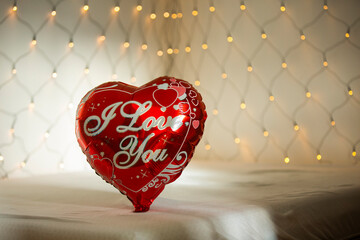 I love you balloon on bedroom bed surrounded with lights net