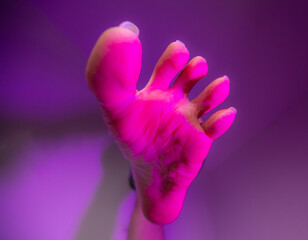 Person sole foot fetish stepping on camera surrounded with artistic colorful pink color - obrazy, fototapety, plakaty