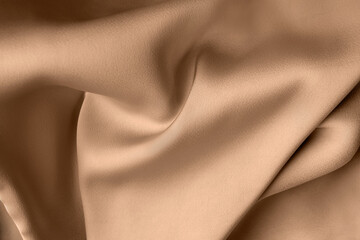 Beige color or light brown creased smooth luxury  satin silk cloth texture decorate background with...