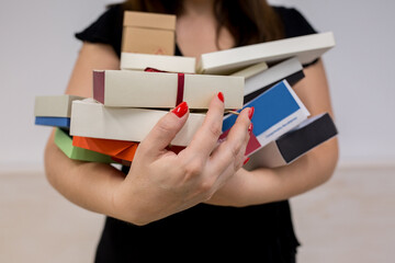 Woman holding a lot of small boxes.
