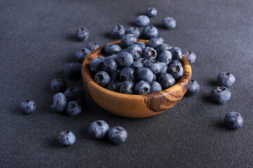 Fresh blueberry berries in wooden bowl