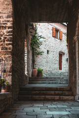 Fototapeta na wymiar Historic architecture in Sibenik, Croatia. Arch and narrow street with steps, stone buildings