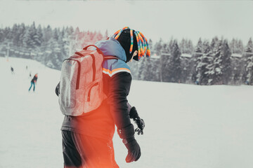 Naklejka premium skier from the back in a helmet in winter near a snowy mountain. the concept of active winter recreation