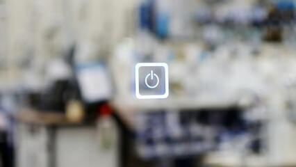 A digital or touch power button against blurred office background