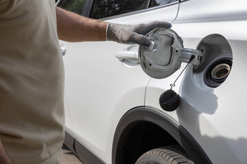 man opens the hatch of the gas tank of the car (Corrected)