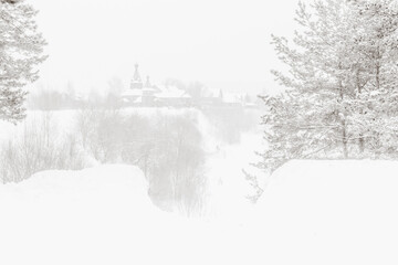 Black and white winter landscape with the church at the hill over the river