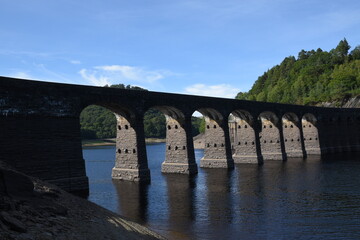 Fototapeta na wymiar Garreg Ddu dam at elan valley during the 2022 heatwave with the water level almost low enough to see the submerged dam under the bridge