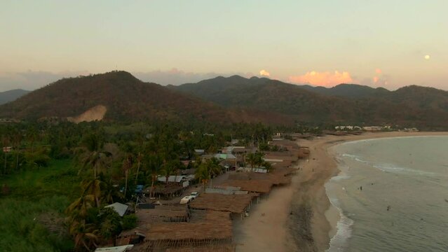 Waterfront Campsites At Maruata Beach With Thatched Roof Cottages In Michoacan, Mexico. Aerial Drone Shot