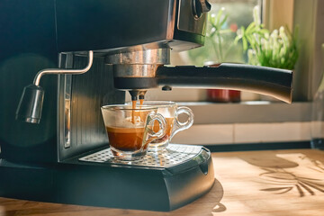 Espresso, awakening aromatic hot drink, pouring in the cups from espresso coffee machine in the...