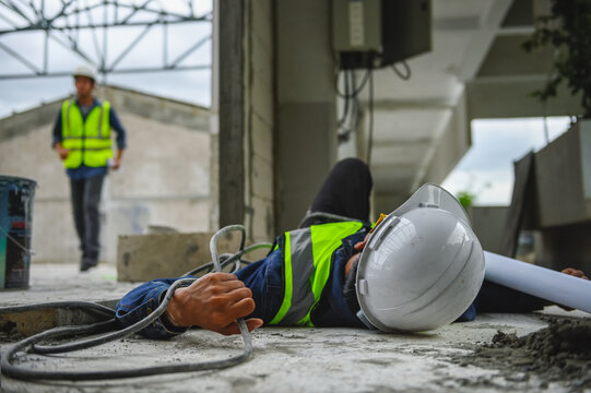 Accident from work of an electrical engineer or maintenance worker lying unconscious and tensed hands on floor near power control box after an accident short circuit while someone is coming to help