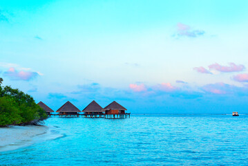 picturesque view of the water villas at sunrise in the Maldives, the concept of luxury travel