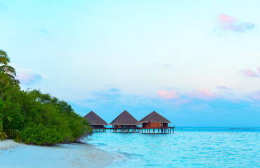 picturesque view of the water villas at sunrise in the Maldives, the concept of luxury travel