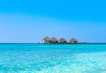 wooden pier in the sea at day time with blue sky and beautiful clouds in the Maldives, the concept of luxury travel