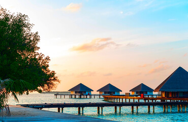 picturesque view of the water villas at sunrise in the Maldives, the concept of luxury travel