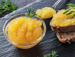 Pike caviar or roe in the bowl on wooden background.