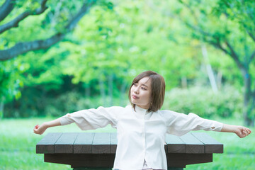 Naklejka premium 緑あふれる公園でくつろぐ女性