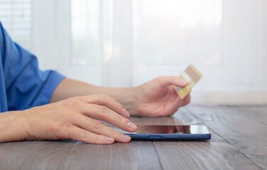 A woman sitting at a table makes purchases, pays bills on the phone via the Internet. Tinting,...