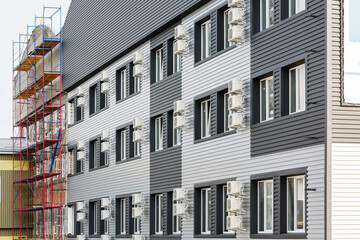 Fototapeta premium Modern building in residential area with many windows and air conditioning near them.