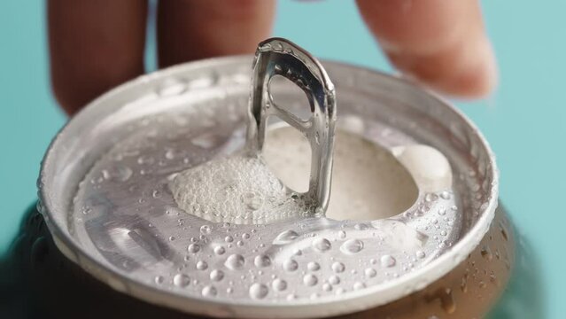 Hand opens can of beer