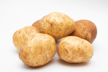 Fresh yellow raw potatoes on a white background