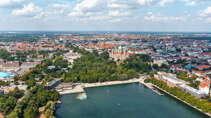 New Town Hall (Neues Rathaus) and Hannover city center aerial view, Germany, Europe. Aircraft point of view aerial shot ft. Maschsee Lake and parks around Hanover-Mitte, the historic heart of the city - obrazy, fototapety, plakaty