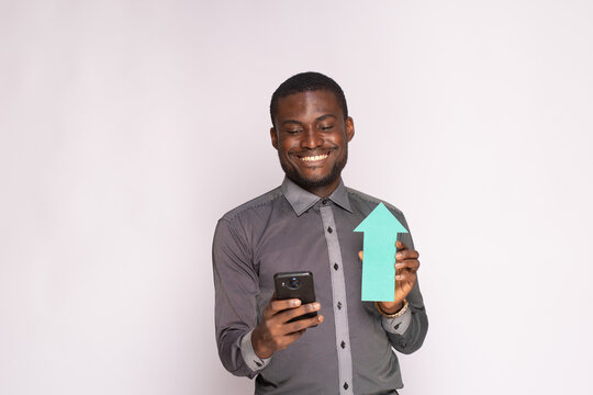 excited african man holding phone and arrow pointing up