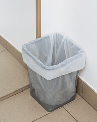 Close up of small trash can with recyclable garbage bag.