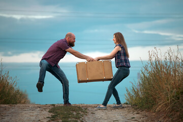Young funny couple fighting over luggage