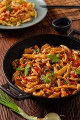 Traditional noodles with shimeji mushrooms and chicken. Prepared in a wok.