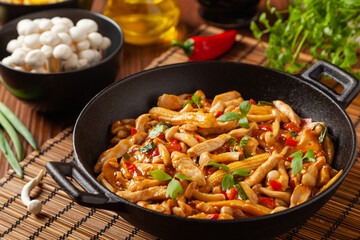 Traditional noodles with shimeji mushrooms and chicken. Prepared in a wok.
