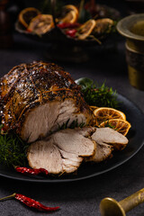 Whole roast pork neck. Christmas decoration. Dark background.