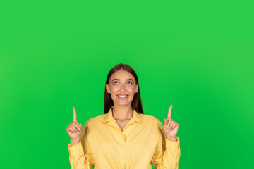 Positive Millennial Lady Pointing Fingers Upward Over Green Background