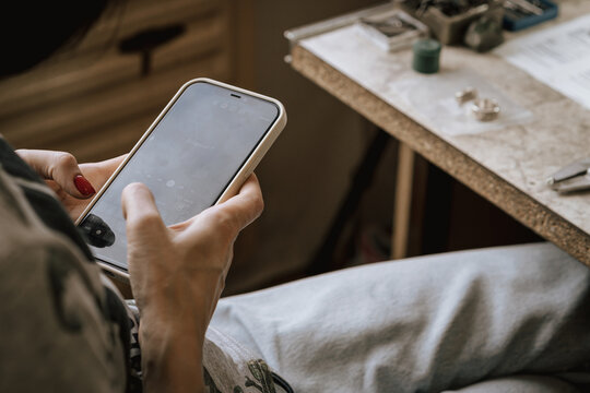 Close up. jeweller using the phone at the working place - Powered by Adobe