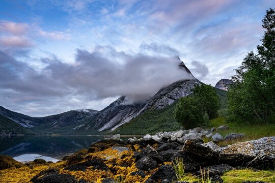 Beautiful landscape with a lake and Stetind mountain covered with clouds. Norway.
