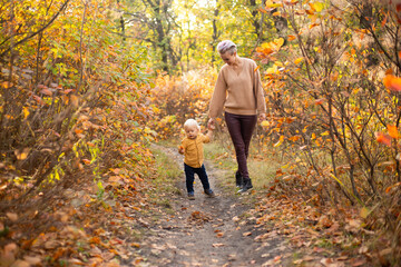 happy family mother and baby son playing and laughing on autumn walk