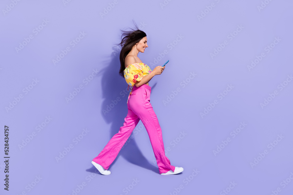 Poster full size profile photo of gorgeous person hold use telephone walking isolated on violet color backg