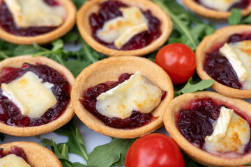 Mini red onion tartlets with goat's cheese on top. Selective focus.