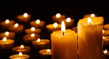 Two burning candles in the dark