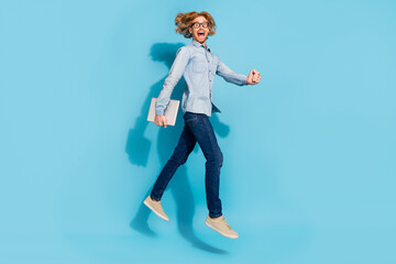 Full length photo of busy hurrying man wear denim shirt spectacles jumping holding modern device...