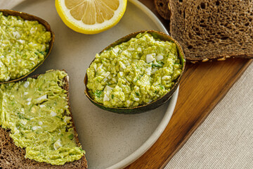 home cooked avocado and egg pate in shells,  diet bread and toast with it on a plate