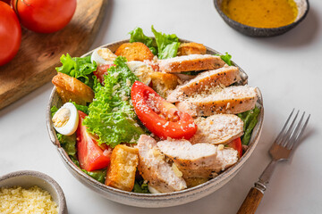 Chicken Caesar salad with chicken breast fillet in a plate on white background. Low carb or keto diet food