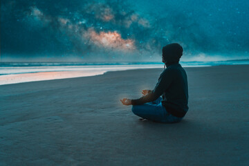 person sitting on the shore of the beach alone meditating at night
